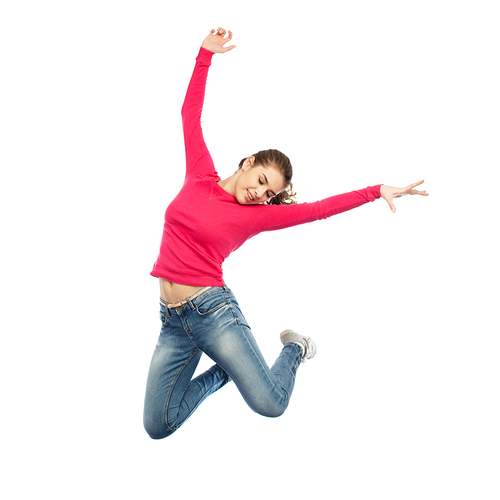 happiness, freedom, motion and people concept - happy young woman jumping or dancing in air over white background