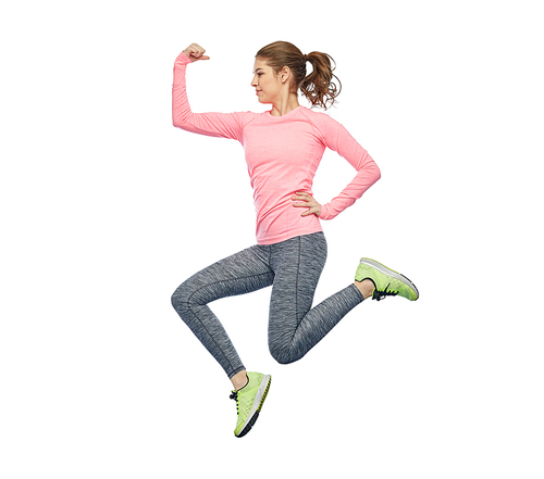 sport, fitness, motion and people concept - happy smiling young woman jumping in air and showing power gesture over white background