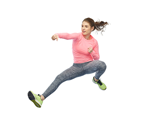 sport, fitness, motion and people concept - happy young woman jumping in air in fighting pose over white background