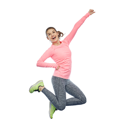 sport, fitness, motion and people concept - happy smiling young woman jumping in air and showing power gesture over white background