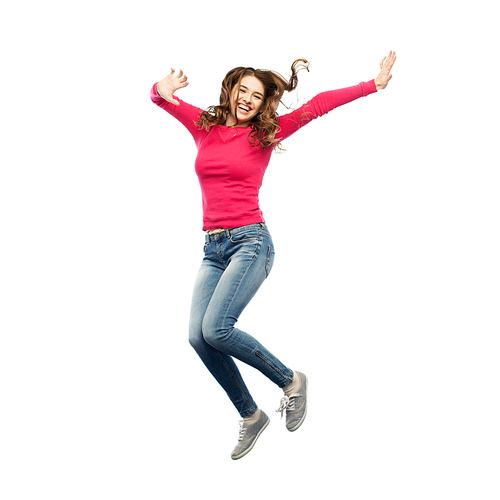 happiness, freedom, motion and people concept - smiling young woman jumping in air over white background