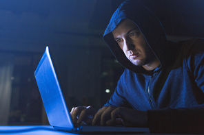 cybercrime, hacking and technology crime - male hacker in dark room using laptop computer for cyber attack
