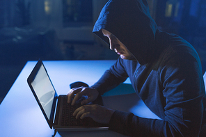 cybercrime, hacking and technology crime - male hacker in dark room writing code or using laptop computer for cyber attack