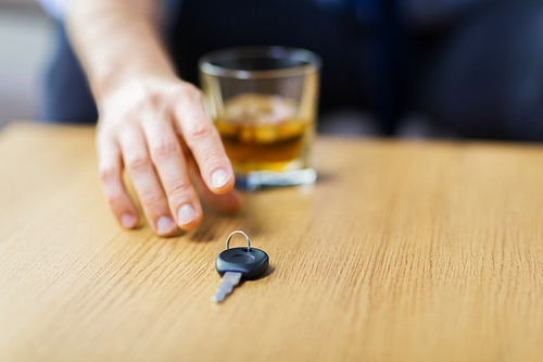 alcohol abuse, drunk driving and people concept - close up of male driver hand with whiskey glass taking car key from table