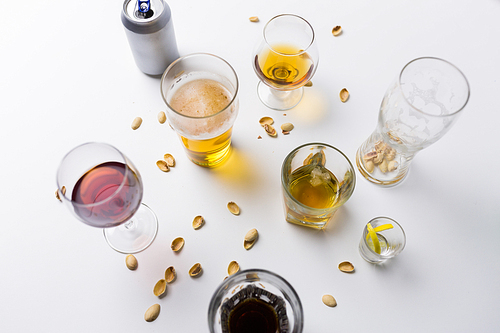 alcohol addiction and drunkenness concept - glasses of different drinks on messy table