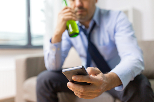 alcoholism, alcohol addiction and people concept - close up of man with smartphone drinking beer