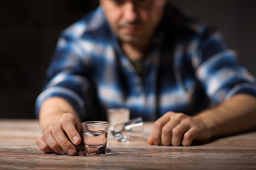 alcoholism, alcohol addiction and people concept - male alcoholic drinking shot at night