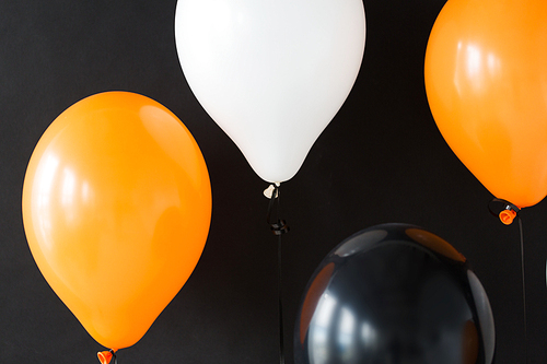 holidays, decoration and party concept - bunch of air balloons for halloween or birthday over black background