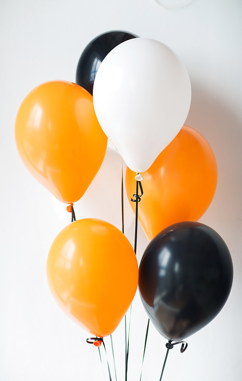 holidays, decoration and party concept - bunch of air balloons for halloween or birthday over white background