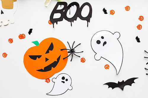 holidays, decoration and party concept - halloween paper decorations over white background