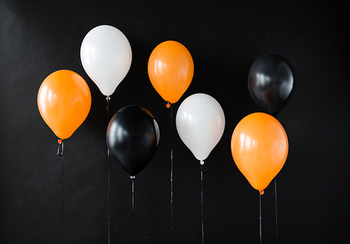holidays, decoration and party concept - bunch of air balloons for halloween or birthday over black background