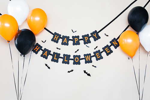 holidays, decoration and party concept - happy halloween festive garland or banner with air balloons over white background