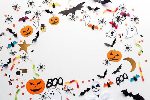 holidays, decoration and party concept - halloween paper decorations and sweets with blank copy space over white background