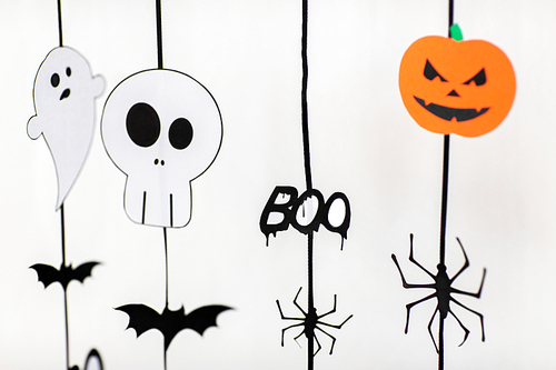 holidays and decoration concept - halloween paper party garlands over white background