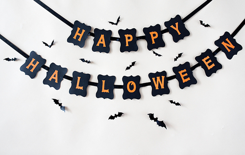 holidays, decoration and party concept - happy halloween festive paper black garland or banner with bats over white background