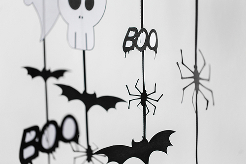 holidays and decoration concept - halloween paper party garlands over white background