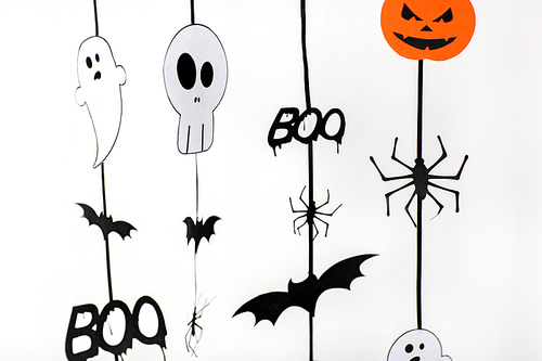 holidays and decoration concept - halloween paper party garlands over white background