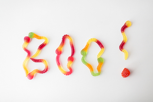 halloween, junk food and confectionery concept - word boo made of gummy worms on white background