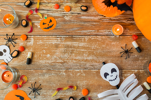 holidays and advertisement concept - halloween decorations and candies with copy space on wooden boards