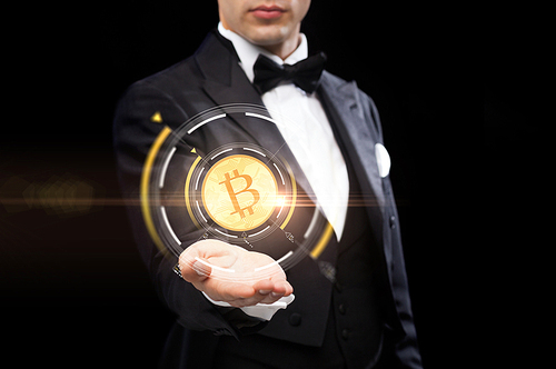 cryptocurrency, finance and business concept - close up of magician hand with virtual bitcoin symbol hologram over black background