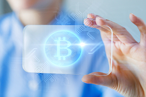 business, technology and cryptocurrency concept - close up of woman hand holding and showing transparent smartphone with bitcoin on screen