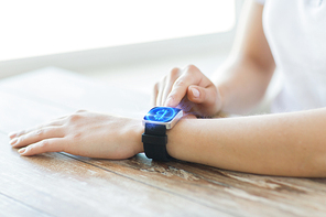 business, technology and cryptocurrency concept - close up of female hand wearing smart watch with bitcoin on screen