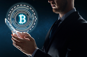 business, cryptocurrency and future technology concept - close up of businessman with transparent tablet pc computer and virtual bitcoin symbol hologram over space background