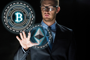 cryptocurrency, financial technology and business concept - businessman with ethereum and bitcoin holograms over black background