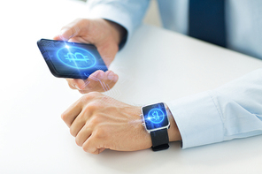 business, technology and cryptocurrency concept - close up of male hand holding smartphone and wearing smart watch with bitcoin on screen