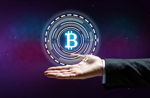 cryptocurrency, finance and business concept - close up of businessman hand with virtual bitcoin symbol hologram over space background