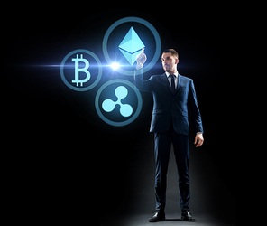 cryptocurrency, financial technology and business concept - buisnessman with virtual bitcoin, ethereum and ripple icons over black background