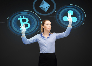 cryptocurrency, financial technology and business concept - smiling businesswoman working with virtual bitcoin, ethereum and ripple hologram over dark background
