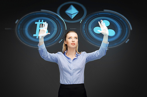 cryptocurrency, financial technology and business concept - smiling businesswoman working with virtual bitcoin, ethereum and ripple hologram over dark background