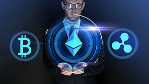 cryptocurrency, financial technology and business concept - close up of businessman with bitcoin, ethereum and ripple icons on virtual screen over dark background