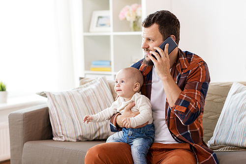family, parenthood and people concept - happy father with little baby boy calling on smartphone at home