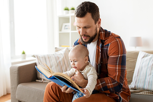 family, parenthood and people concept - happy father and little baby boy with book at home