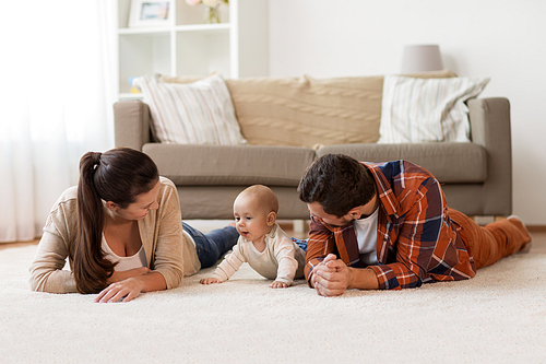 family, parenthood and people concept - happy mother and father playing with baby at home