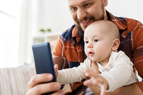 family, parenthood and people concept - happy father with little baby boy taking selfie at home