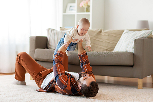 family, parenthood and people concept - happy father playing with little baby boy at home