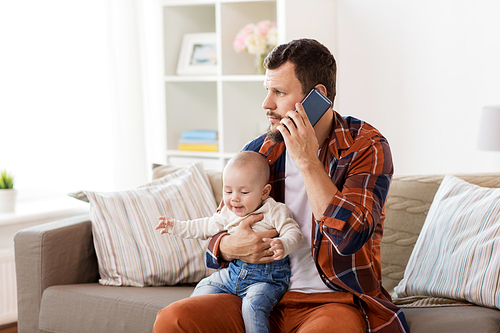family, parenthood and people concept - father with little baby boy calling on smartphone at home
