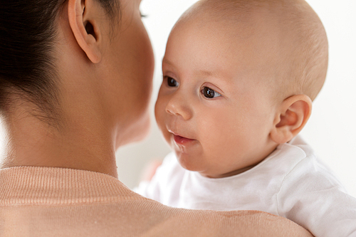 family, motherhood and people concept - close up of happy little baby boy with mother