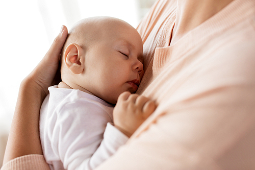 family, motherhood and people concept - close up of mother holding sleeping little baby boy