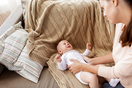 family, motherhood and people concept - mother soothing crying little baby boy at home