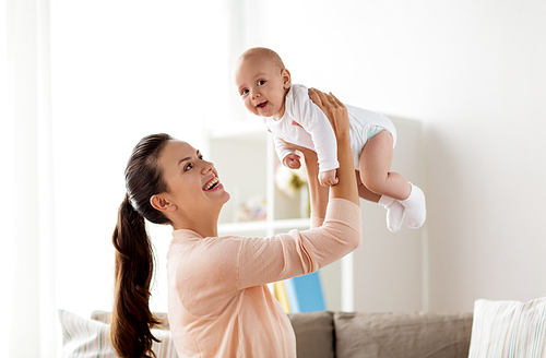 family, motherhood and people concept - happy mother playing with little baby boy at home
