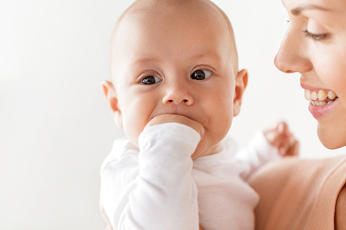 family, motherhood and people concept - close up of happy mother with little baby boy sucking fingers