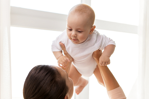 family, motherhood and people concept - happy mother playing with little baby boy at home