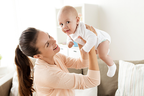 family, motherhood and people concept - happy mother playing with little baby boy at home