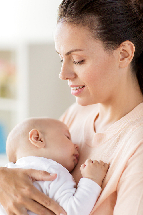 family, motherhood and people concept - close up of mother holding sleeping little baby boy at home