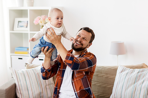 family, parenthood and people concept - happy father playing with little baby boy at home