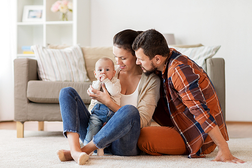 family, parenthood and people concept - happy mother, father with baby at home